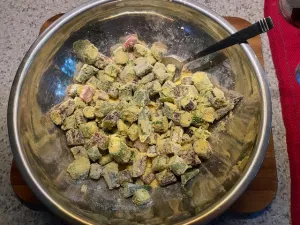 Okra added to flour mixture in pan