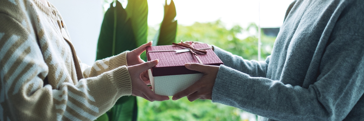 Stock photo close up of one person handing another person a gift box