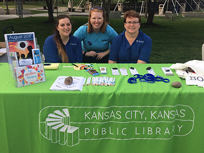 KCKPL outreach staff at the park with table of literature and giveaways