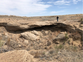 A person standing n top of a cave formation