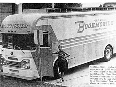 Black and white photo of bookmobile bus with hand-written caption (not legible)