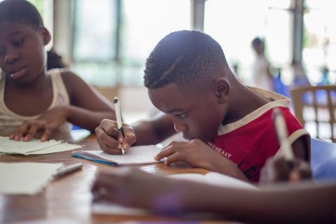 Children doing homework at a desk.