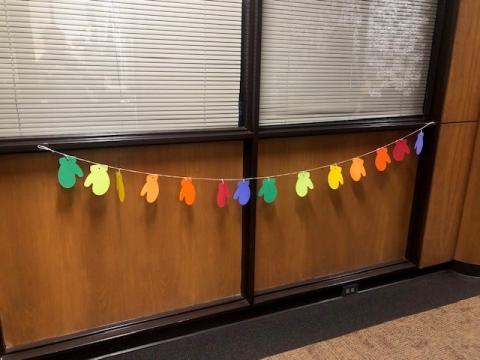 Holiday garland craft hangs from a window inside the library. 