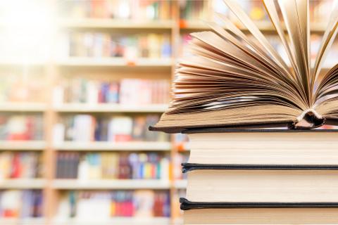 Stack of books in front of shelves