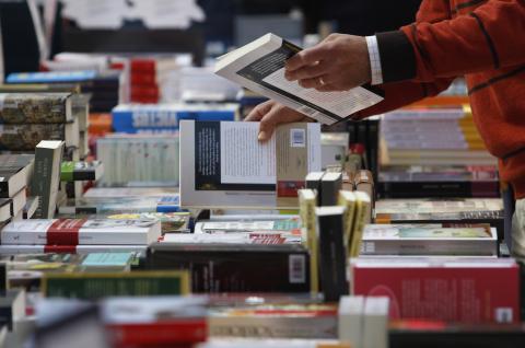 A person looking through a book sale bin