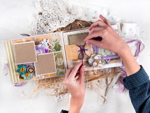 hands creating a scrapbook