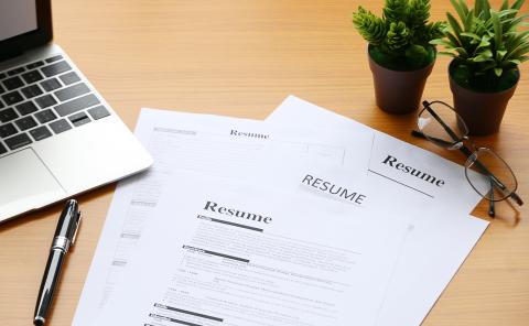 Sheets of paper on the table with Resume written on them