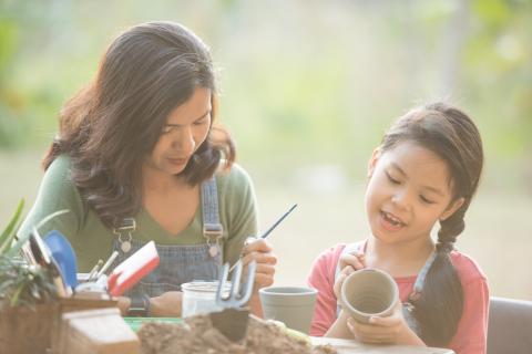 Woman and child painting plant pot