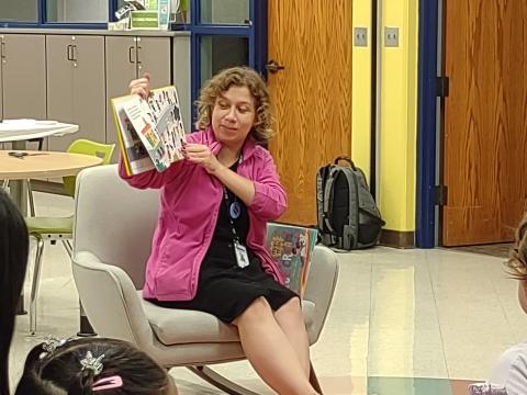 Woman in rocking chair reads picture book