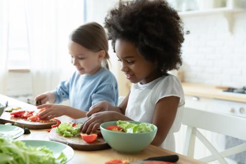 two girls chopping vegetables