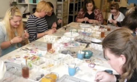 Women enjoying a class to learn to make their own sparkling earrings.