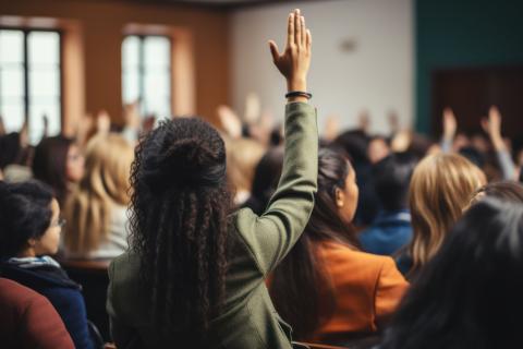 student raising hand in class setting