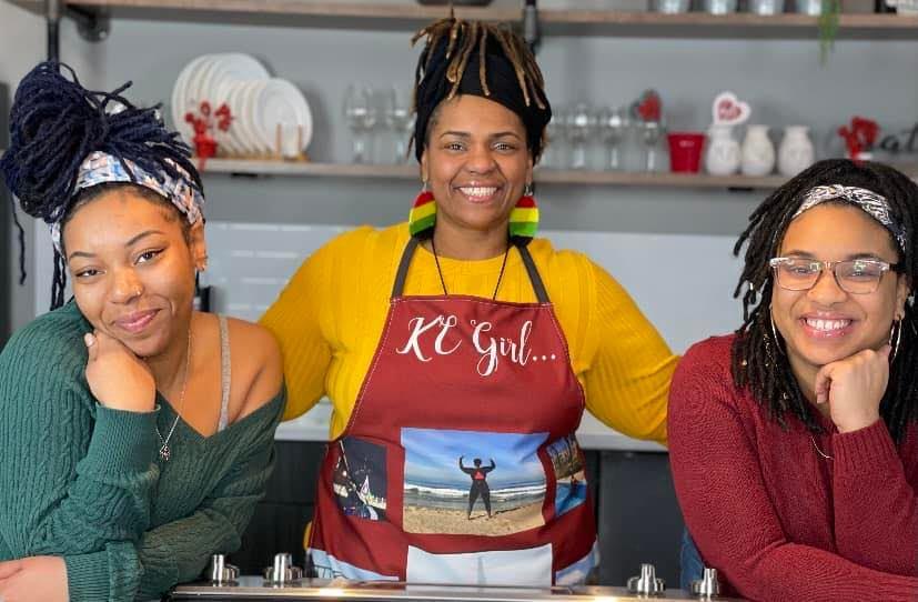 Stacey and her two daughters stand in the middle of a kitchen with their arms around one another. 