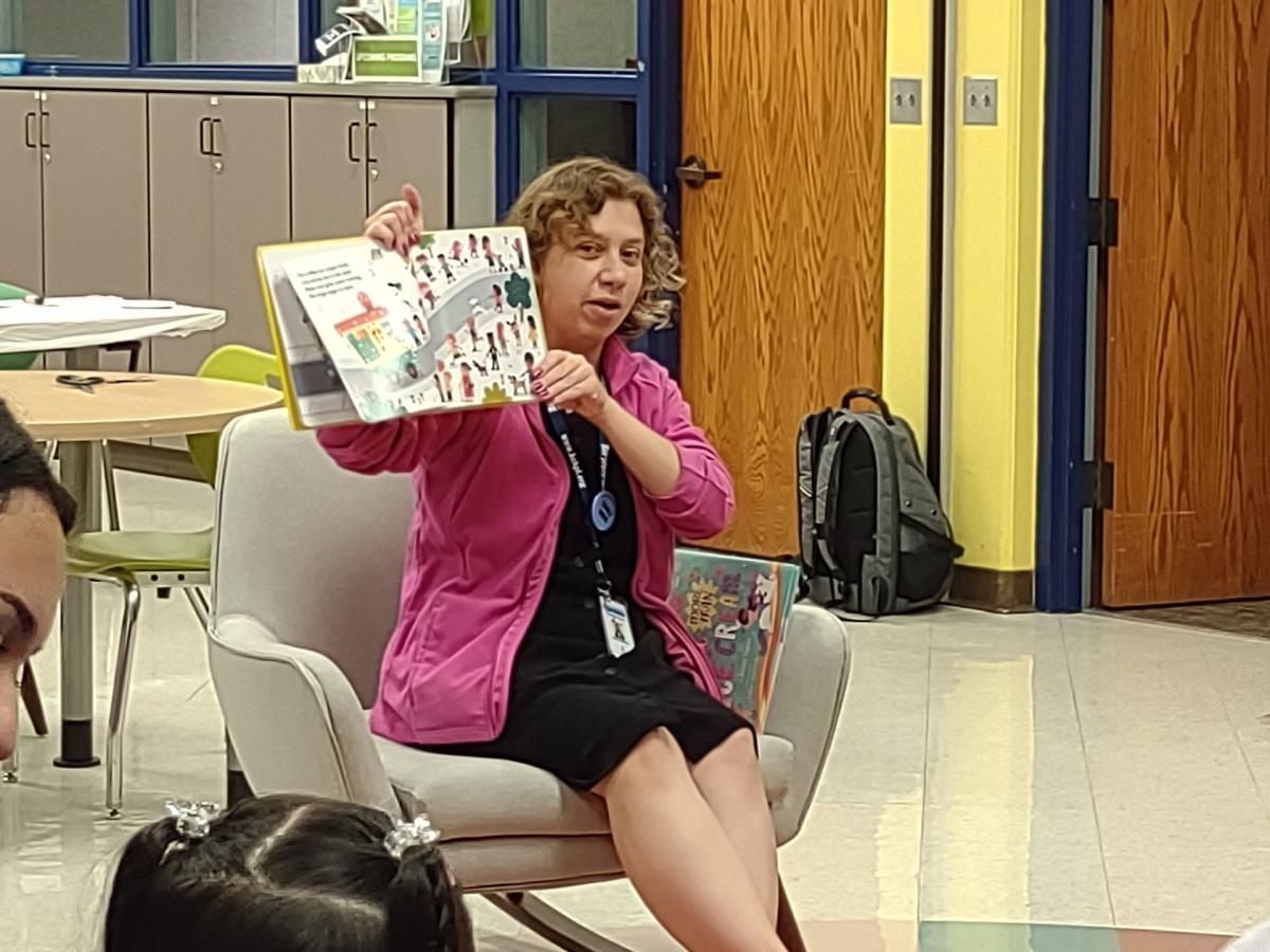 Woman in rocking chair reads a picture book