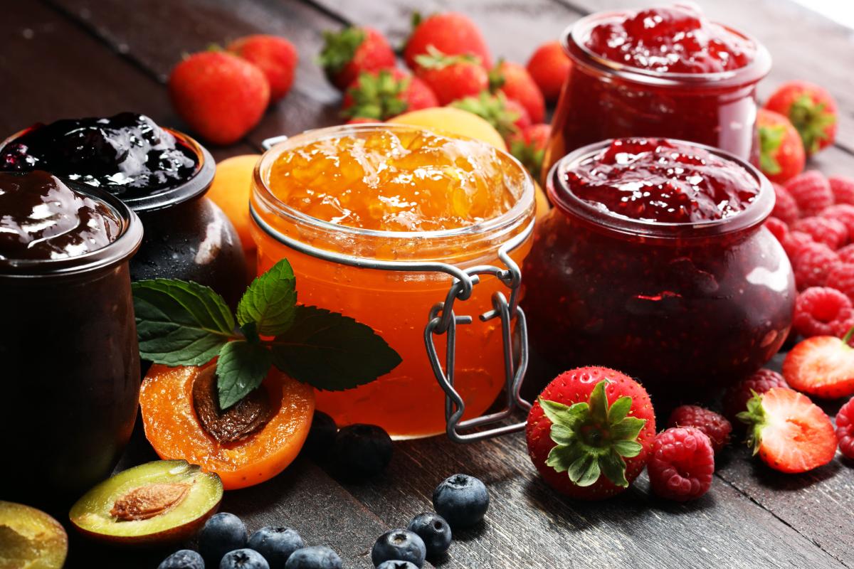 jelly jars surrounded by fresh fruit