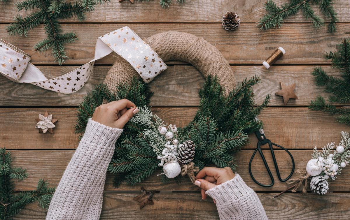 Woman's hands decorating wreath